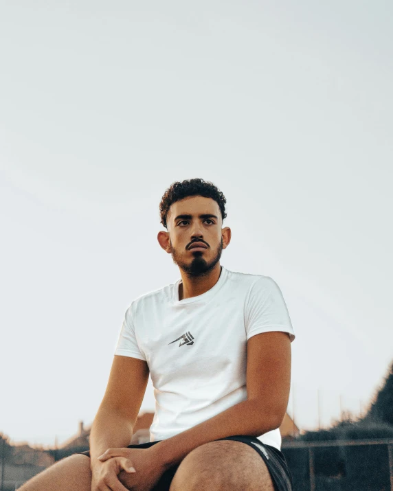 the young man is sitting down posing for a picture