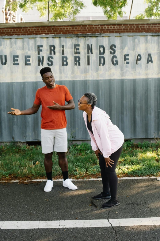 a man and woman in front of a sign on a road