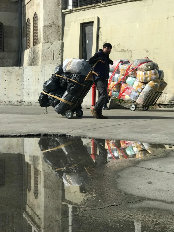 a man hing luggage down the street with other suitcases