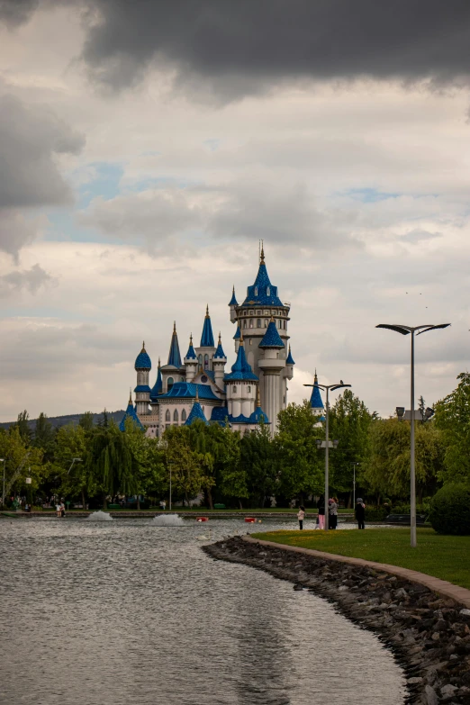 a castle on the edge of a river and trees