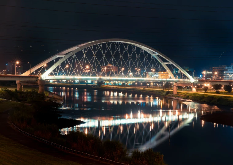a large bridge spanning over a river at night