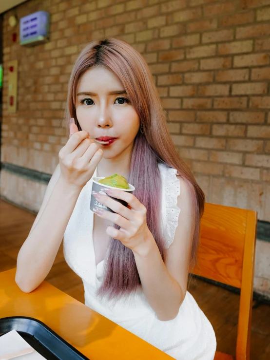 a woman in white sitting down eating food