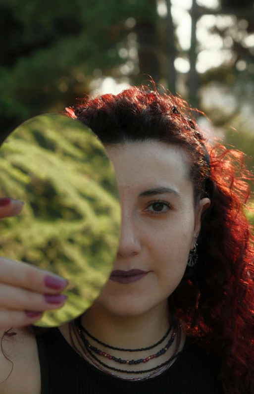 a woman standing outside holding a frisbee in her hand