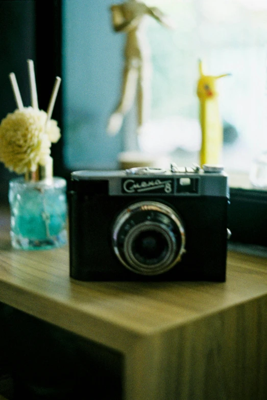 a camera sits on top of a table with flowers