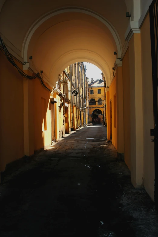 a dimly lit city street in the middle of a yellow wall