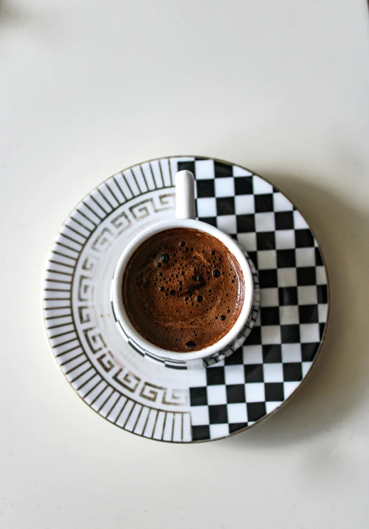 a small cup of coffee is set on a saucer