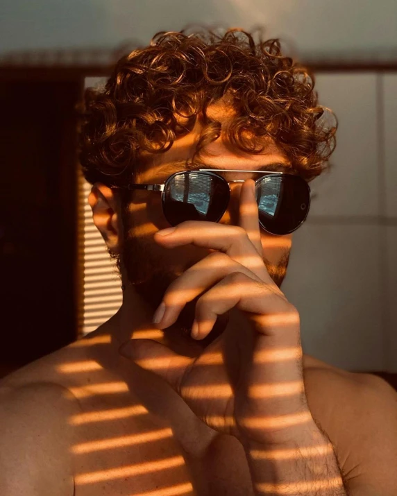 a man wearing shades and glasses smoking a cigarette