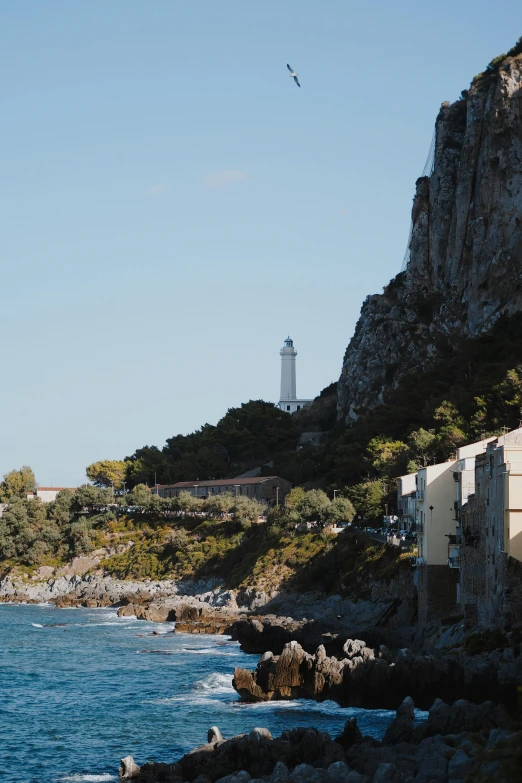 the coast line with buildings, water, and a light house in the background