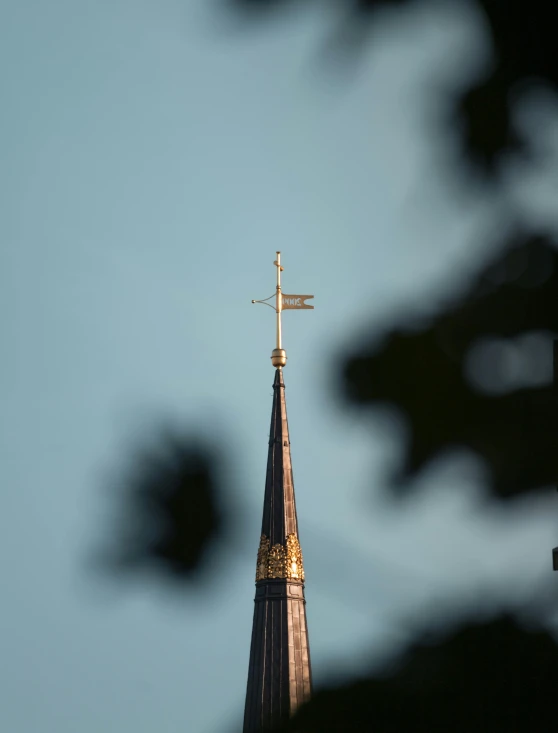 a church steeple with a golden cross on top