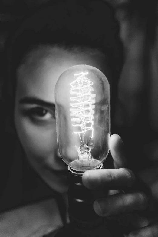 a young man holding a small light bulb