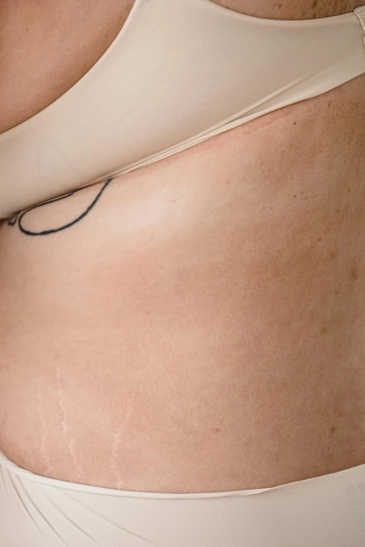 a tattoo of a black line is on the side of this woman's bikini