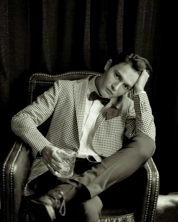 a man sitting on top of a chair next to a bottle