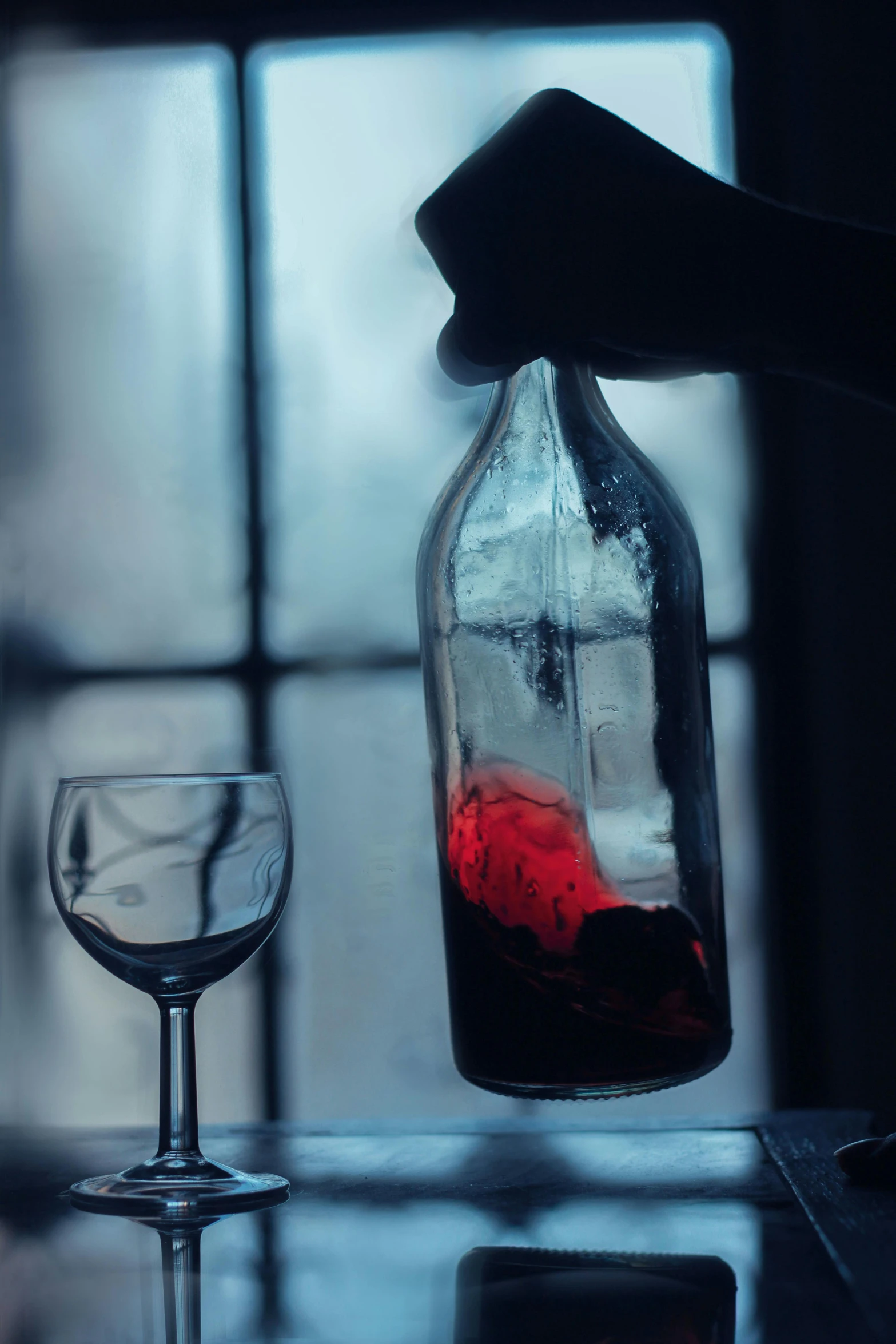 a wineglass sitting on top of a table next to a bottle