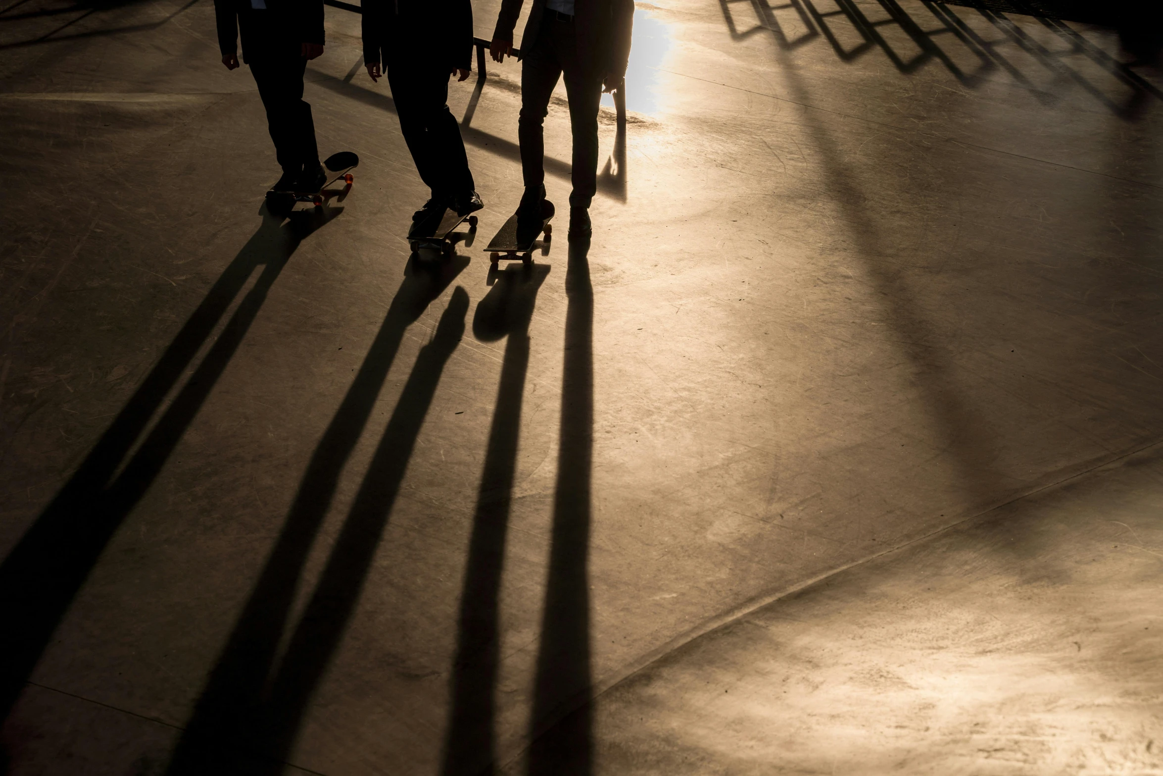 two skate boarders riding their boards down an inner ramp