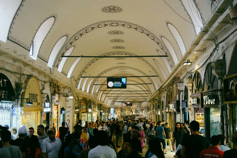 a crowded shopping mall has many people walking around