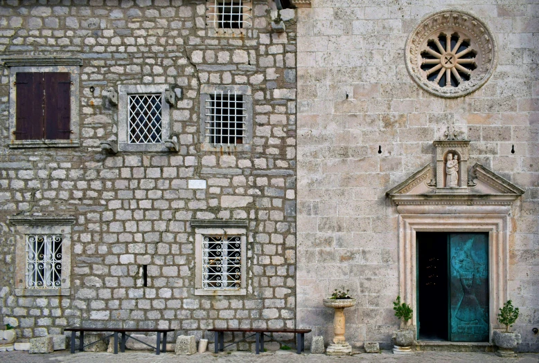 a stone building with three windows and a clock on the wall