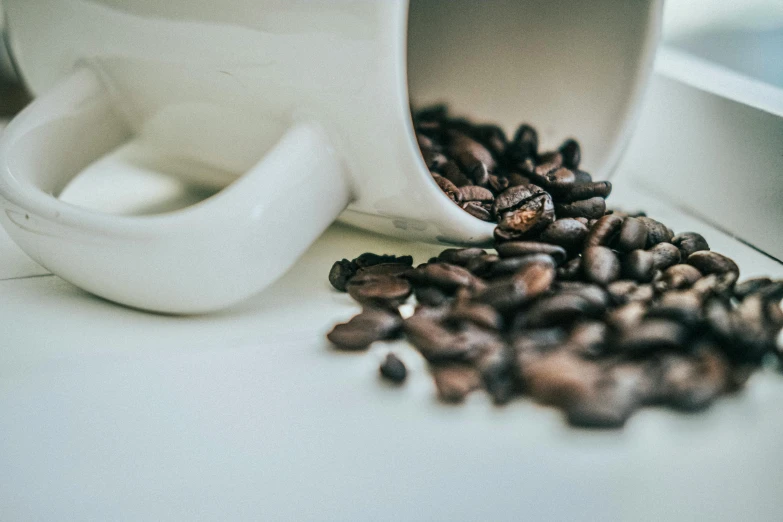 roasted coffee beans spilling out of a cup