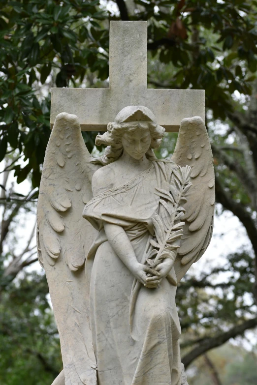 a stone angel statue on a graveyard with an angel on it's head