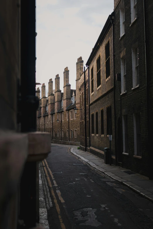 an empty street with a brick building in the background