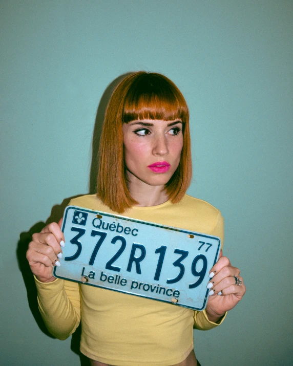 a woman wearing a yellow top and a license plate