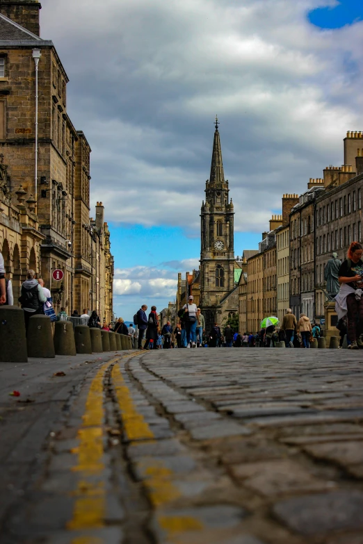 street of buildings in front of people walking and sitting