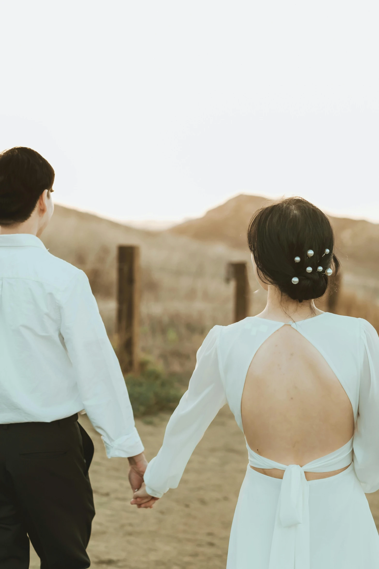 a couple hold hands and walk through the desert