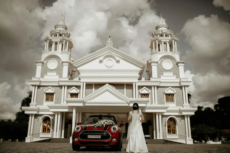 a woman is standing next to a car in front of a building