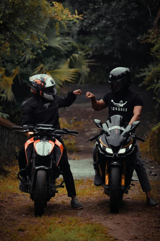 two people riding on motorcycles in a wooded area