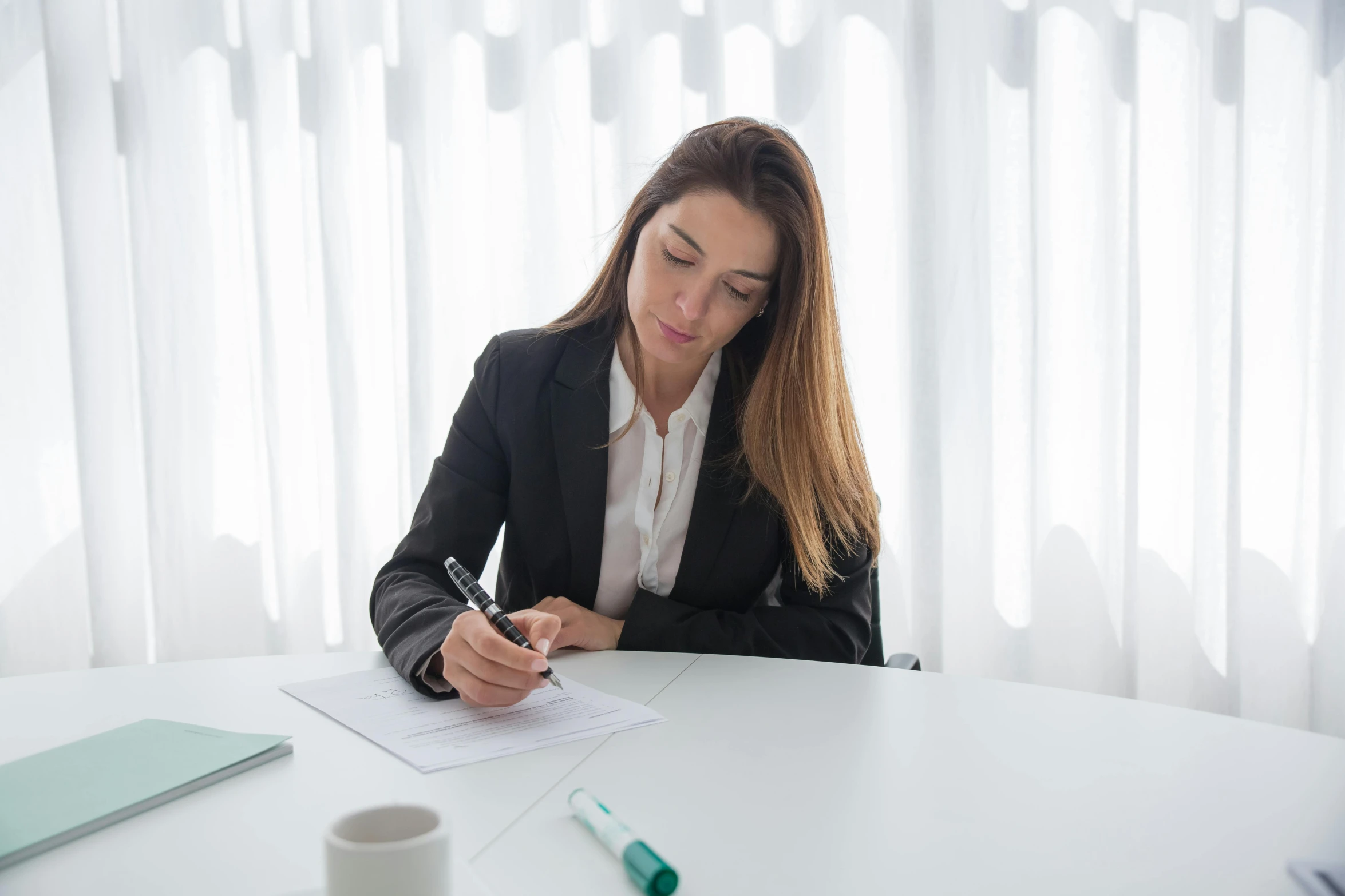 a woman signing soing with a pen and paper