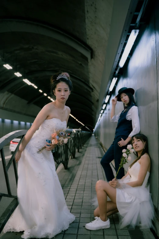 an asian bride and two other girls on the sidewalk