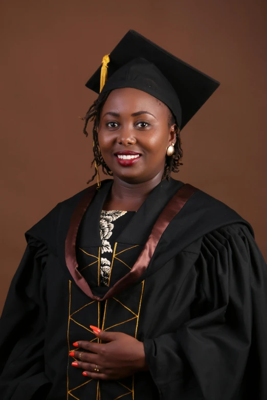 a woman in a black graduation gown and gold tassel poses for a po