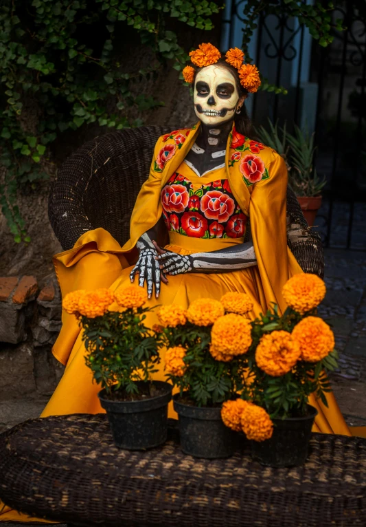 a skeleton sitting in a chair with some flowers