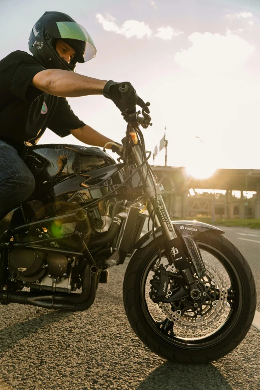 a man wearing black sits on a motorcycle