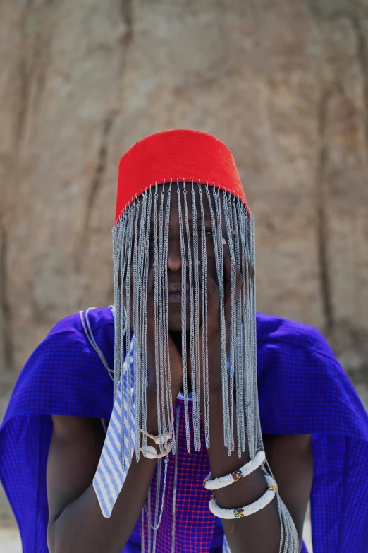 a woman wearing bead, fringe and a red hat