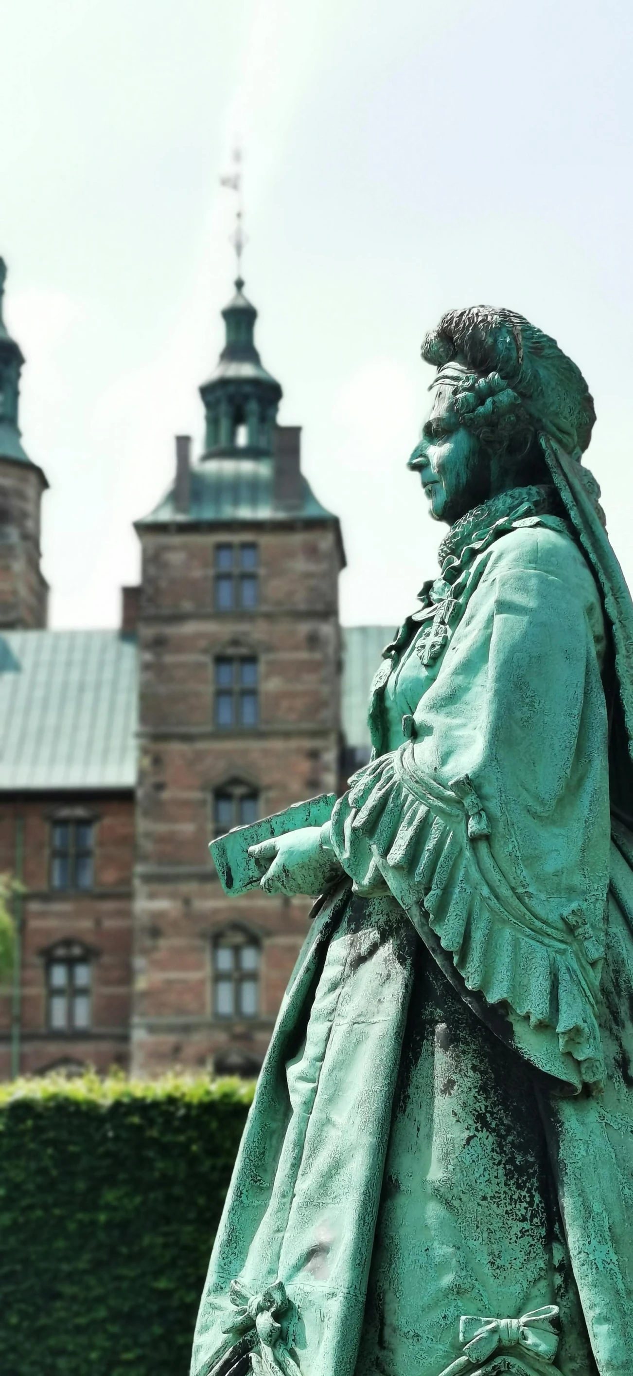 a statue with a coat on standing in front of a building