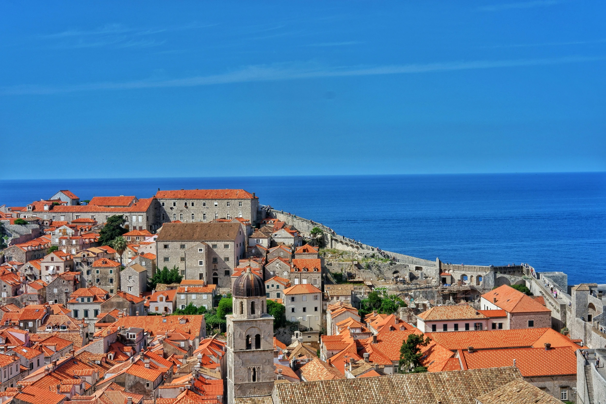 an aerial view of orange tiled roofs overlooking the ocean