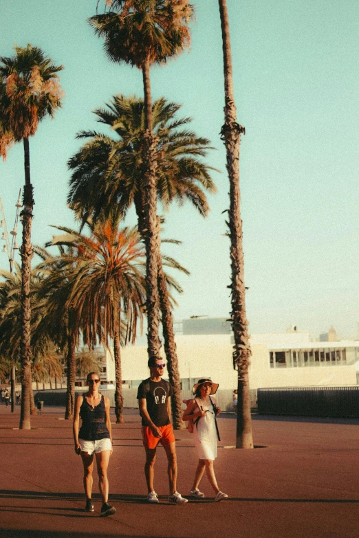 the group of people are walking together through the park