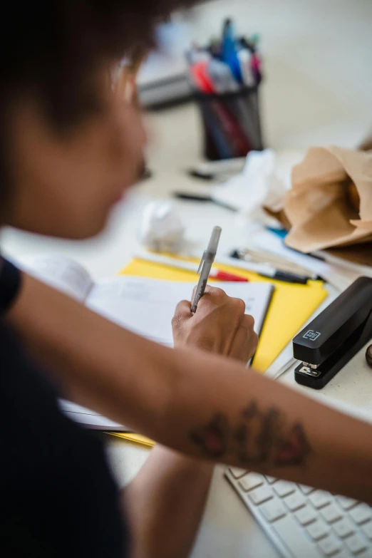 a person with a pencil on their hand writing