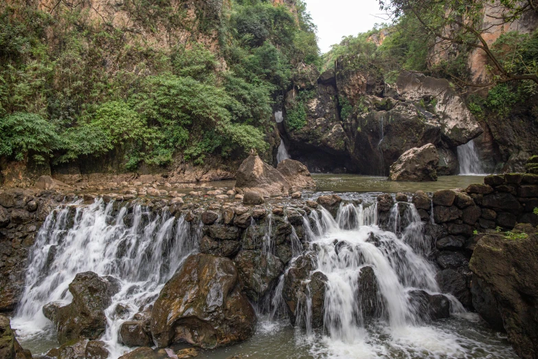 a waterfall on a river surrounded by trees