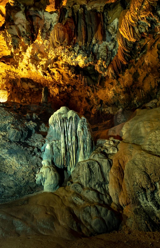 a cave containing a lot of large rocks and a brown wall