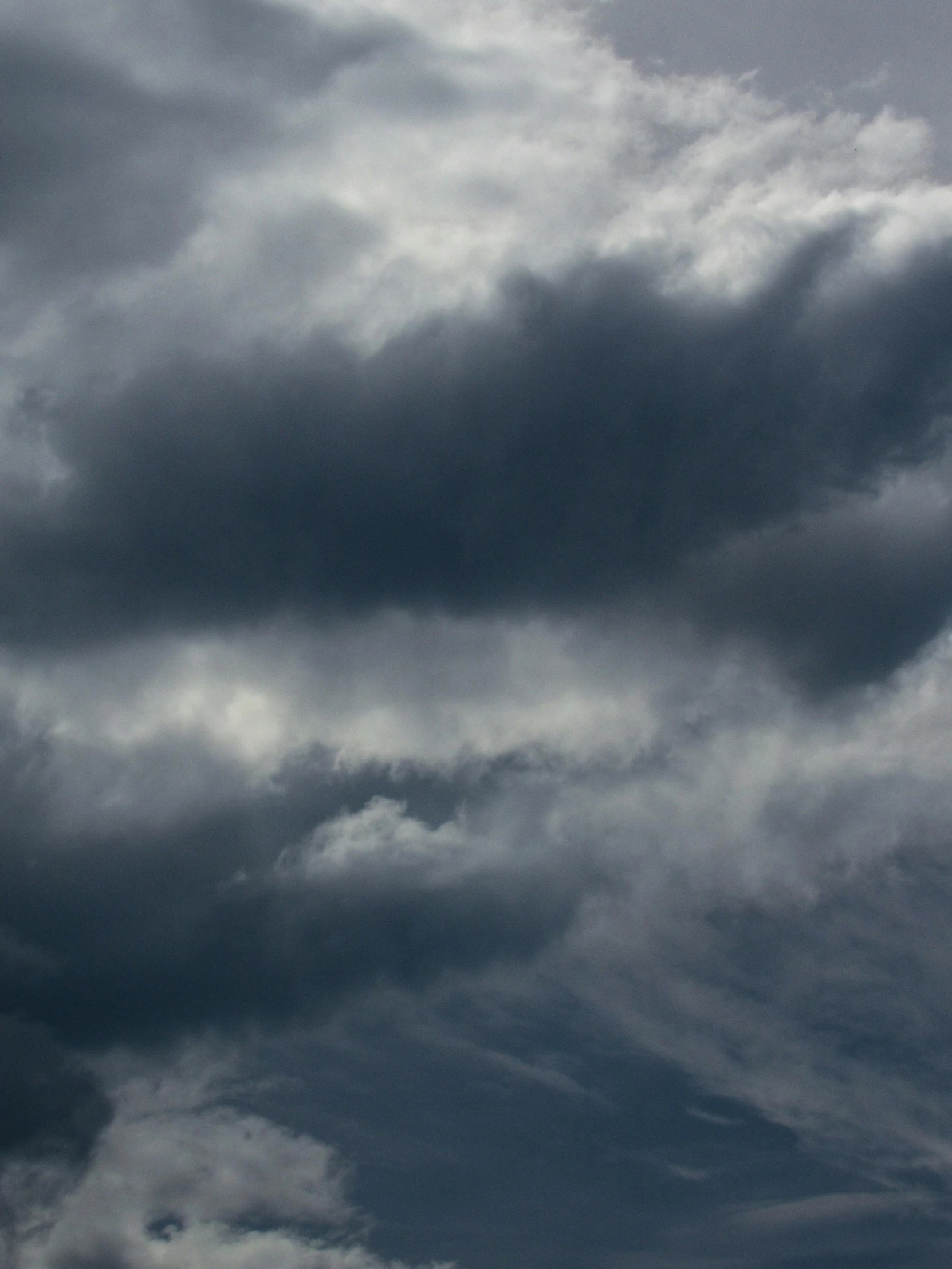 a jet flying through the cloudy sky on a cloudy day