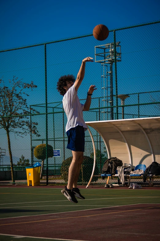 a man jumps into the air to grab a basketball with his hand