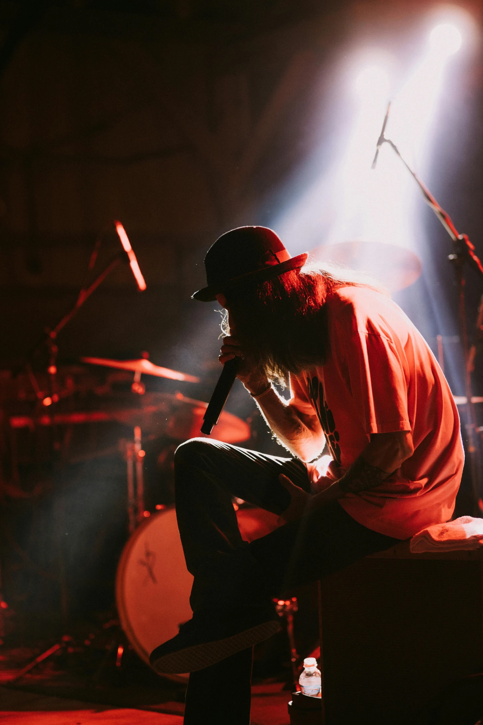 a man sits on a stool while playing the guitar