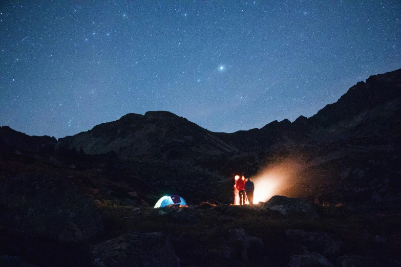 a couple of people standing in front of some mountains