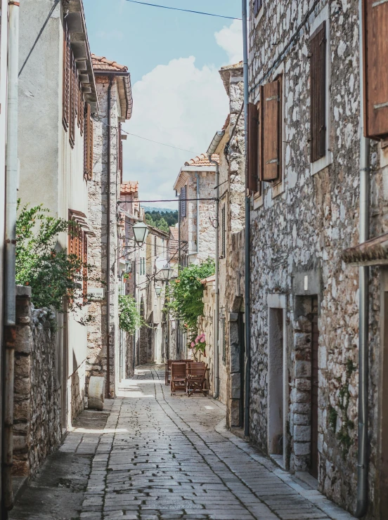 a narrow alley with stone walls and windows