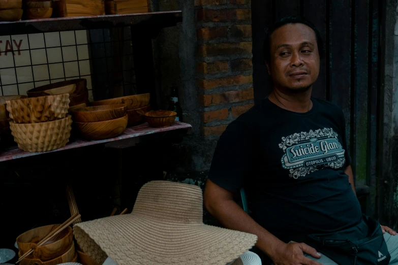 a man is sitting in his kitchen with a hat on his lap