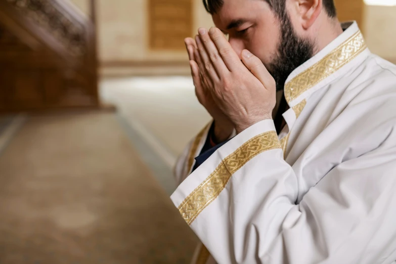 a man praying with his hands together inside