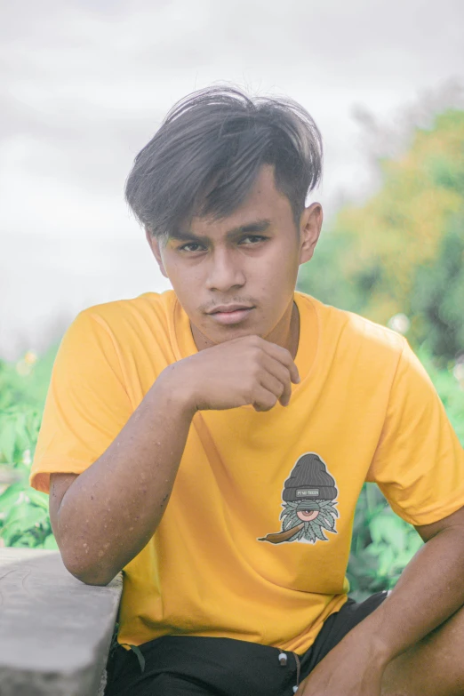 a boy with a yellow shirt sitting in a field