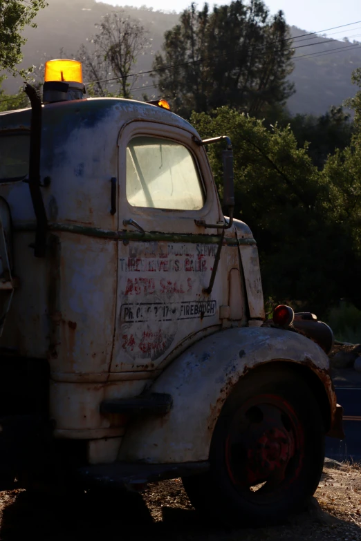 an old semi truck parked in front of a mountain