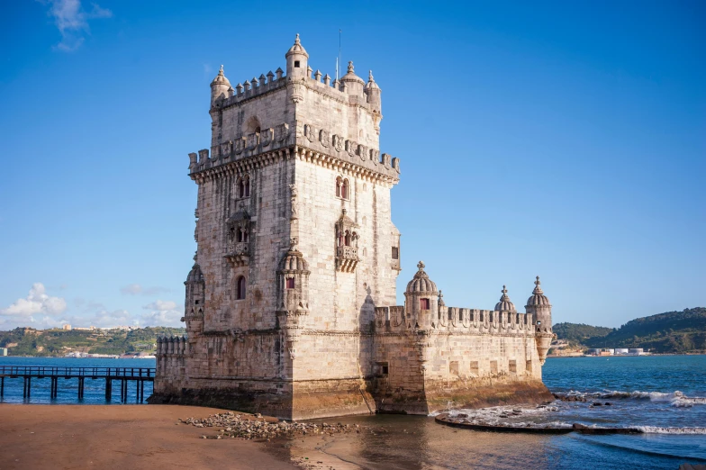 large clock tower on the shore next to blue water